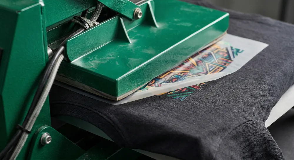 DTF-Transfer wird mit einer Transferpresse auf ein T-Shirt gepresst
