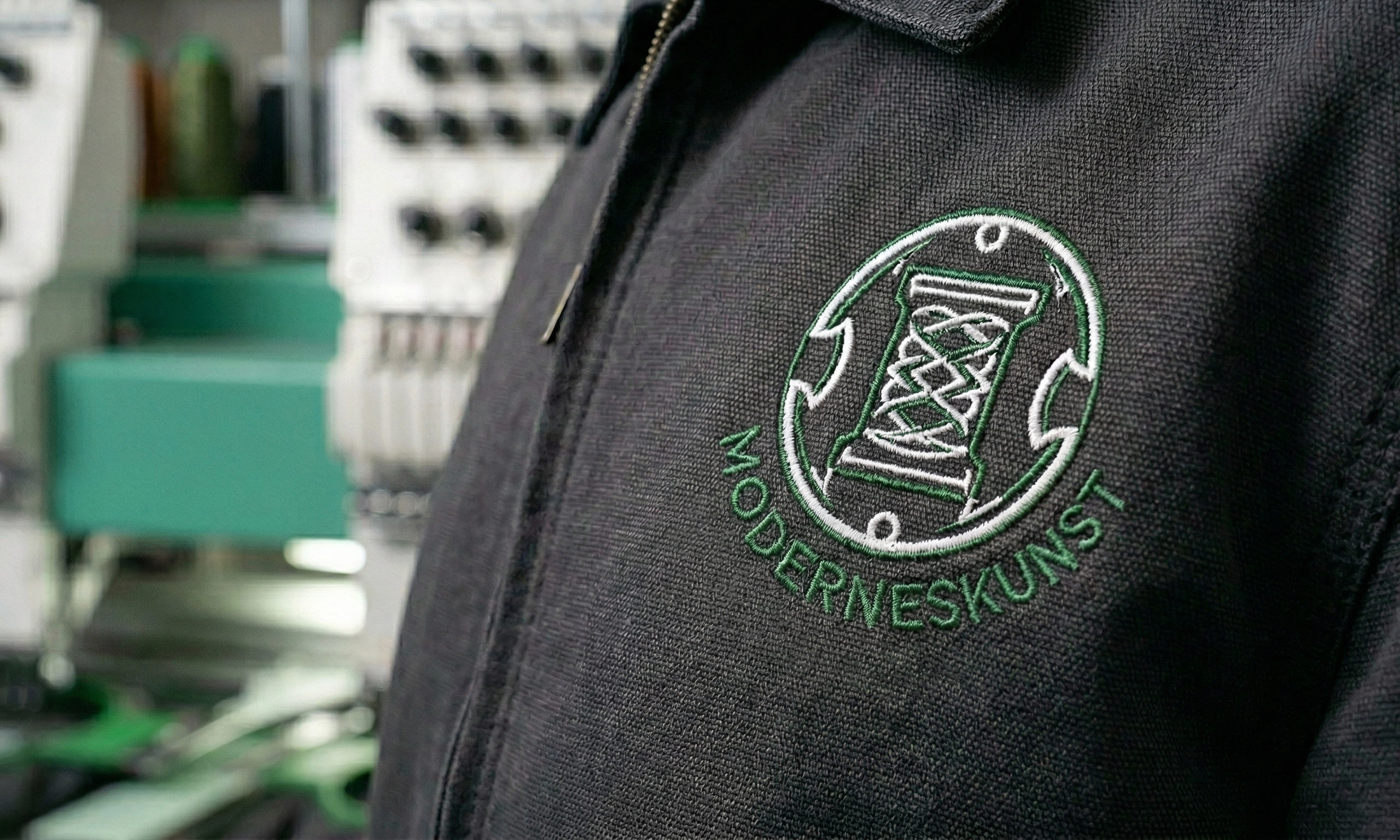 Stickerei auf dunkler Arbeitsjacke – Firmenlogo professionell gestickt bei Printerado in Fürth